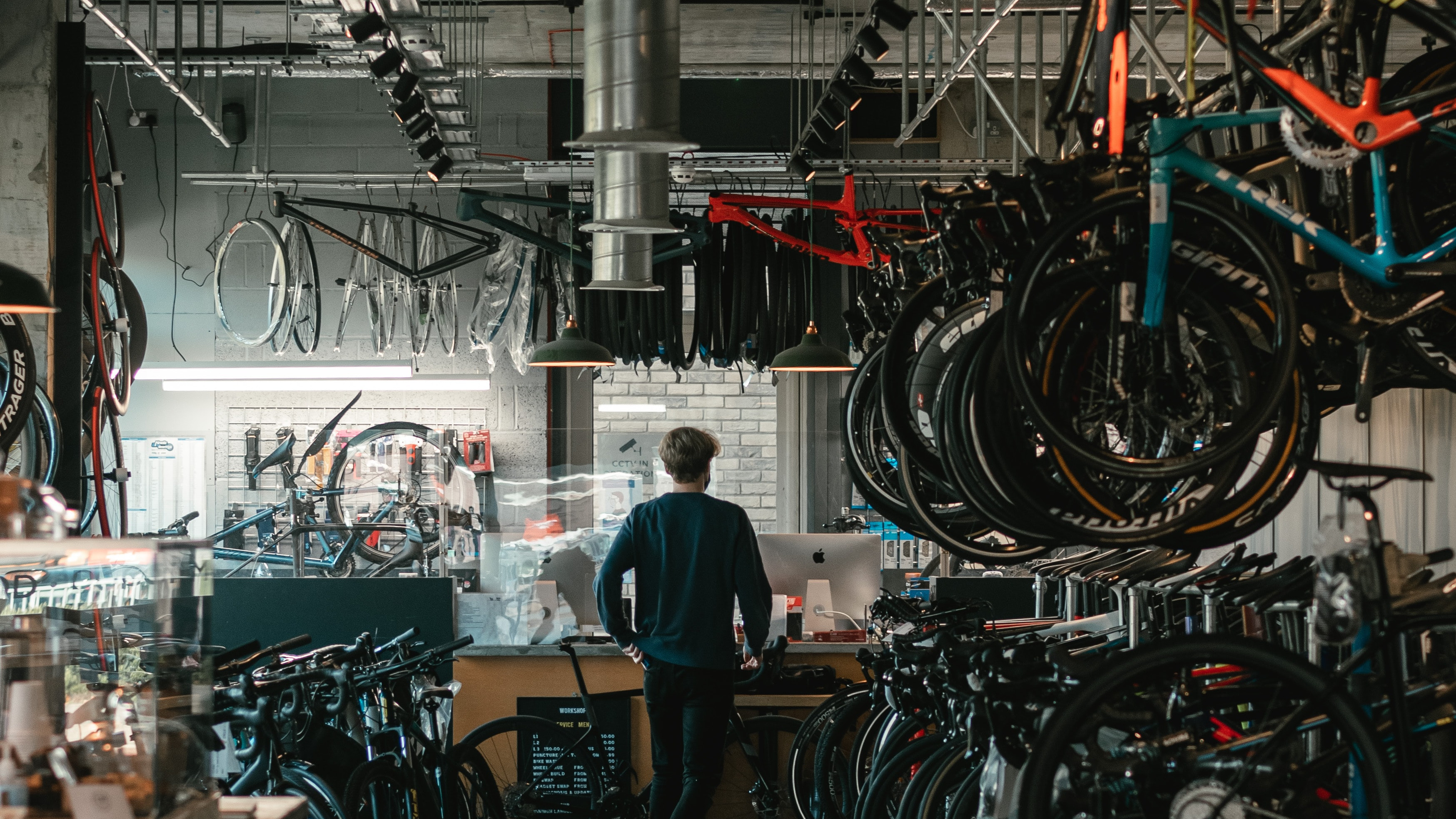 A man in a shop surrounded by bikes.